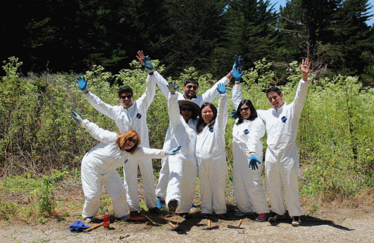 Volunteers pose for a photo in white suits