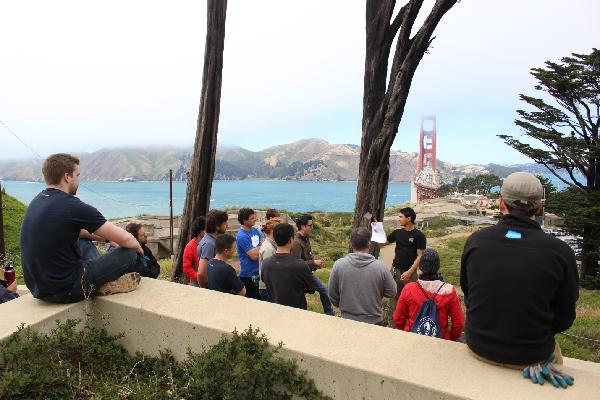 Volunteers gathered around a program leader in a scenic spot