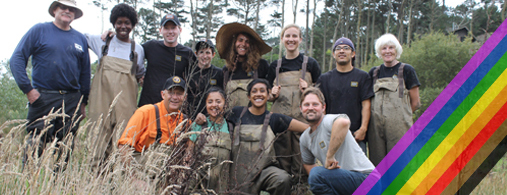 People in waders take a group photo at Muir Beach