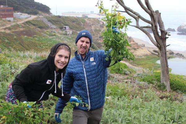 Volunteers holding up pulled weeds